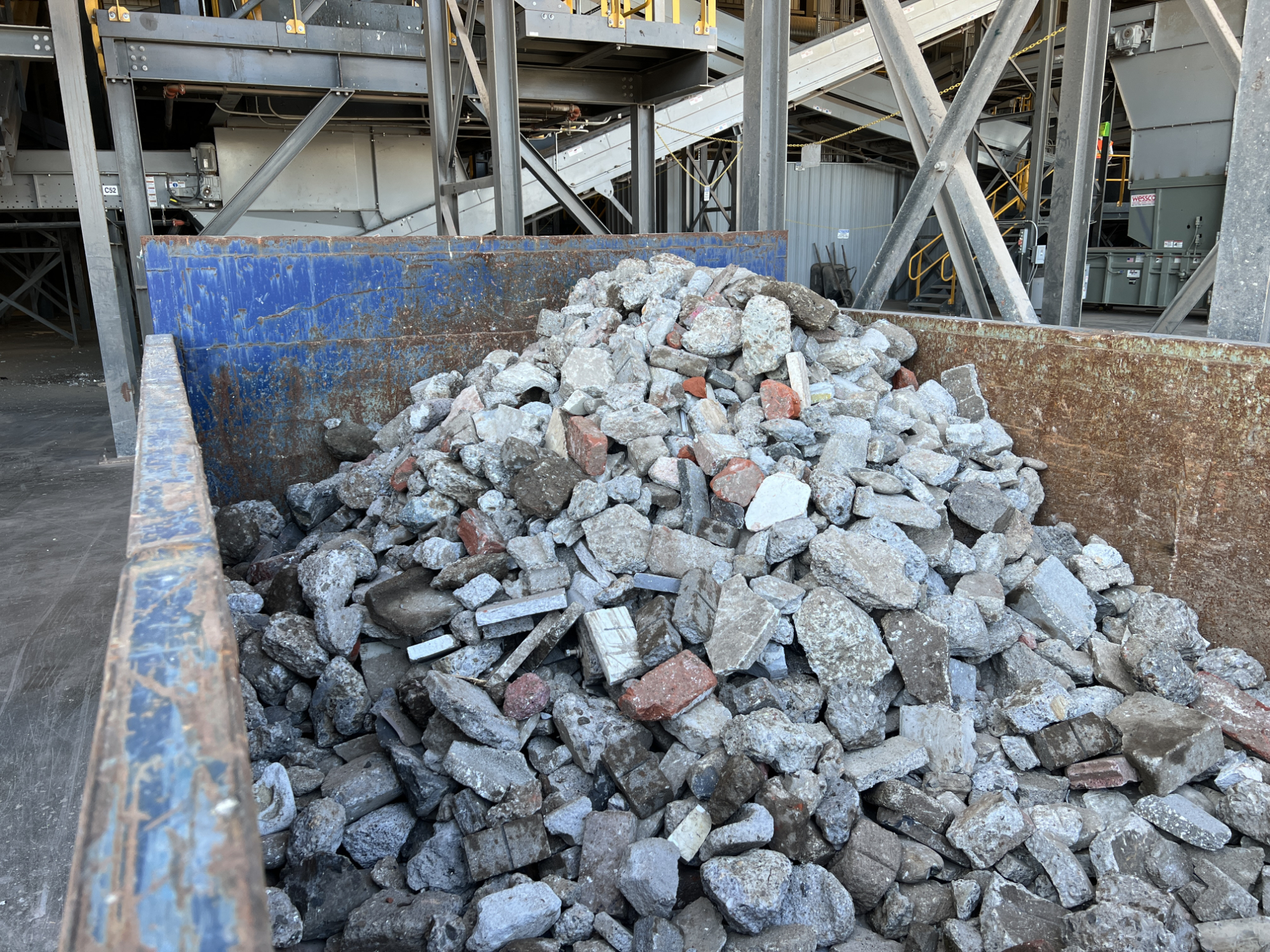 container full of recovered rock and pieces of concrete at sorting facility
